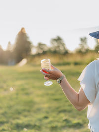 Cropped hand of woman holding wine glass outdoors