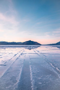 Salt flats against sky during sunrise