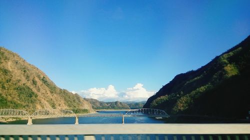 Scenic view of sea and mountains against blue sky