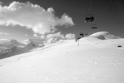Overhead cable car over snowcapped mountains against sky