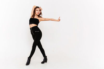 Full length portrait of woman standing against white background