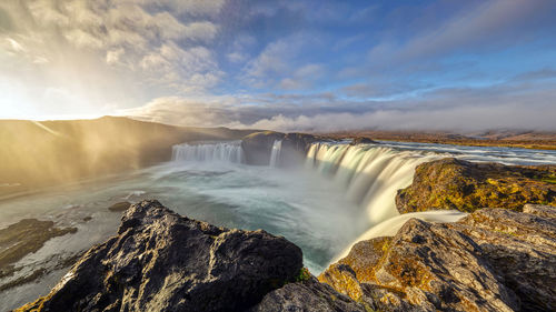 Scenic view of waterfall against sky