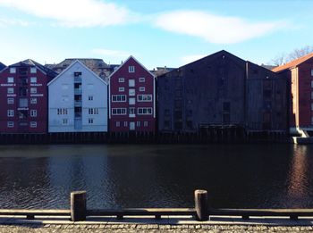 Buildings by lake against sky in city