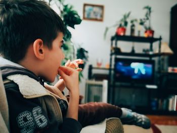 Full length portrait of boy sitting at home