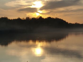 Scenic view of lake against sky during sunset