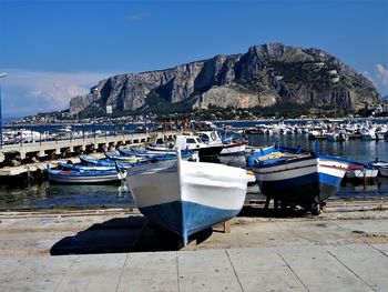 Sailboats moored on sea against sky