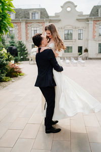 Full length of couple embracing while standing outdoors