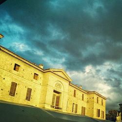 Low angle view of building against cloudy sky