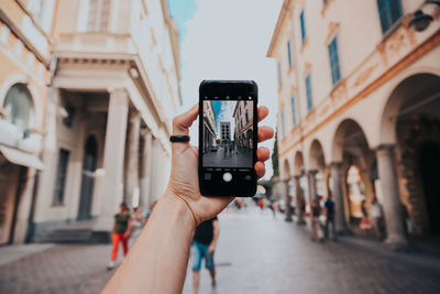 Midsection of woman photographing in city