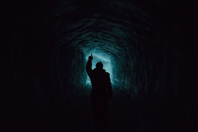 Silhouette man standing in tunnel