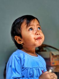 Portrait of cute boy looking away at home