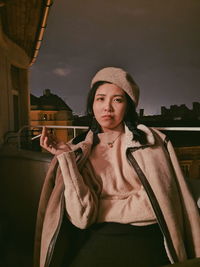 Portrait of young woman standing against sky