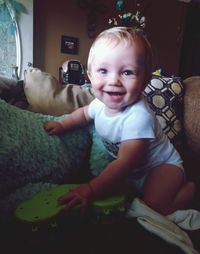 Portrait of smiling boy sitting at home