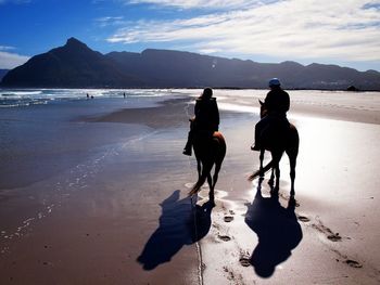 People riding horses on beach