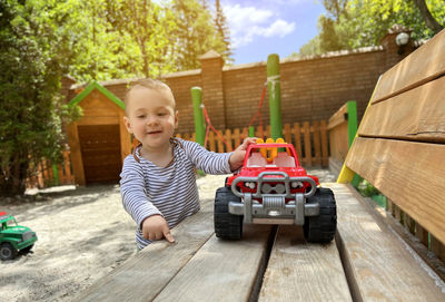 Portrait of boy playing with toy car