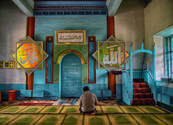 Rear view of man sitting outside building