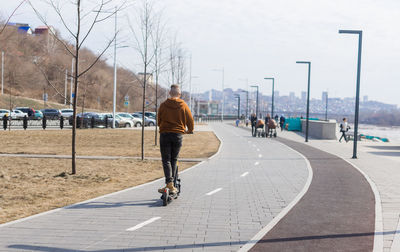 Rear view of man walking on road