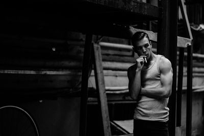 Man looking away while holding cigarette