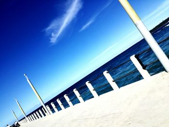 Low angle view of beach against clear blue sky