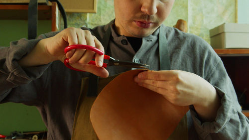 Midsection of man holding hands at home