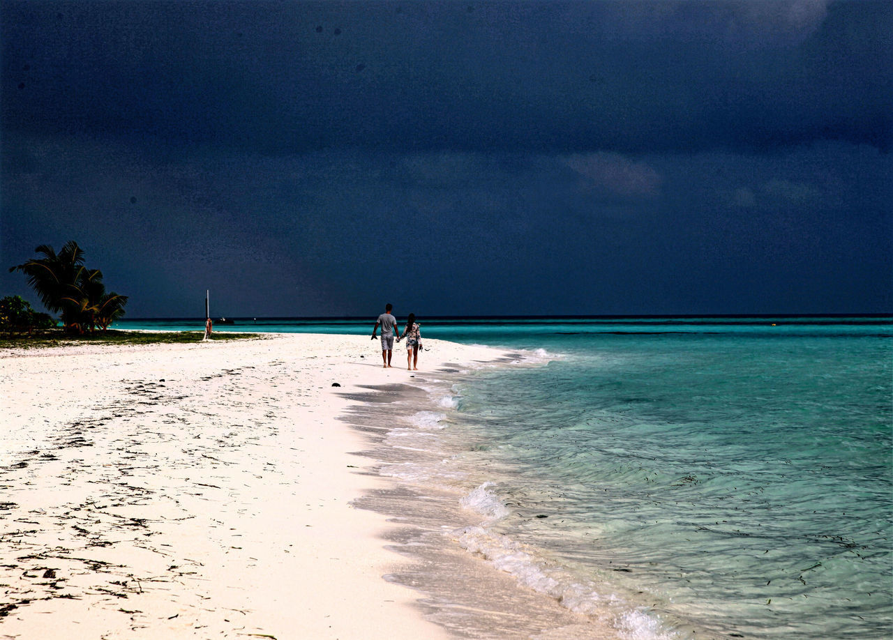 PEOPLE AT BEACH AGAINST SKY