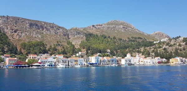 Scenic view of lake by buildings against clear sky