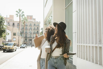 Young woman standing on mobile phone in city