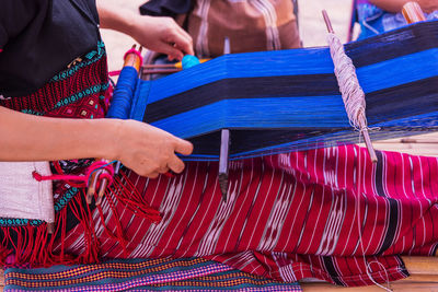 Midsection of woman weaving