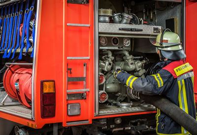 Firefighter attaching hose to machinery