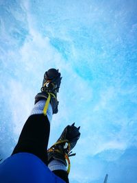 Low angle view of a young man against clear blue sky