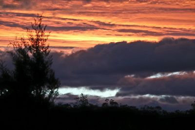Scenic view of dramatic sky over silhouette landscape