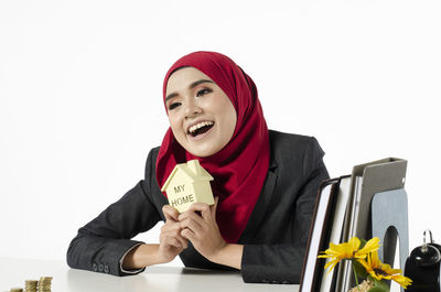 Portrait of a smiling young woman against white background