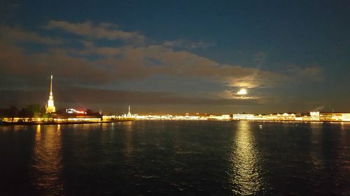 Illuminated cityscape against sky at night