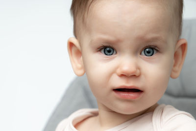 Close-up of cute baby boy against white background