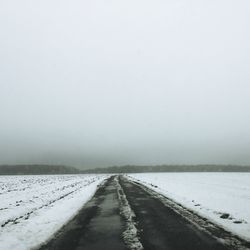 Snow covered road against sky