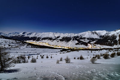 Scenic view of snow covered mountains against sky at night