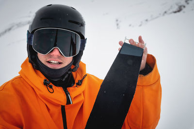 Portrait of a cheerful young caucasian skier at a ski resort against the backdrop of foggy mountains