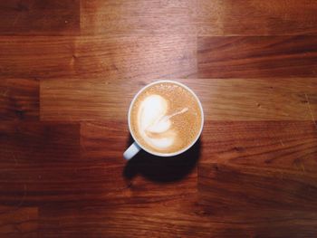 Directly above shot of coffee cup on wooden table