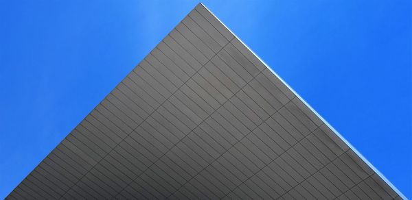 Low angle view of modern building against clear blue sky