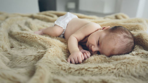 Cute baby girl sleeping on bed