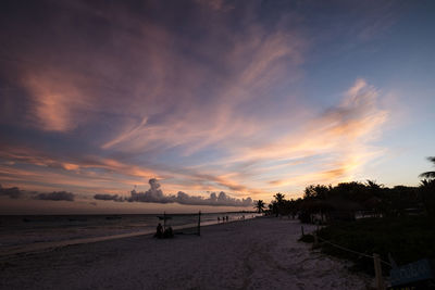 View of beach against cloudy sky during sunset
