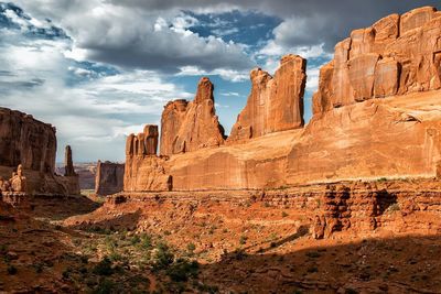 Scenic view of rock formations against cloudy sky