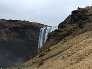 Scenic view of waterfall against sky