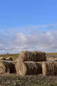 Hay bales on field against sky