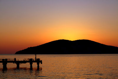 Calm lake against silhouette mountain