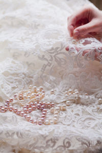 Cropped hands of woman stitching wedding dress