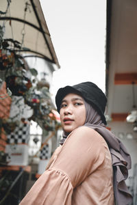 Portrait of young woman looking away outdoors