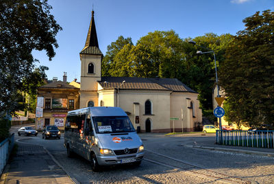 Vehicles on road against sky in city