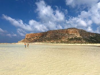 People on beach against sky