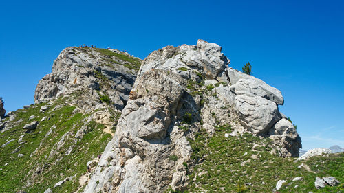 Low angle view of rocks against blue sky